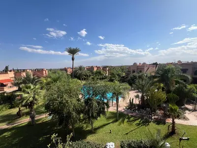 a view of a park with palm trees and buildings at La Perle de Marrakech by Atlas Golf Resort in Marrakech