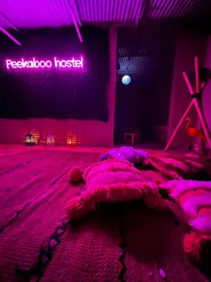 a bedroom with a bed in a room with a neon sign at Peekaboo Hostel in Marrakech