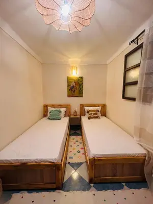 two beds in a small room with a chandelier at Peekaboo Hostel in Marrakech