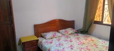 a small bedroom with a bed with a floral bedspread at les porte de guiliz appartement in Marrakech