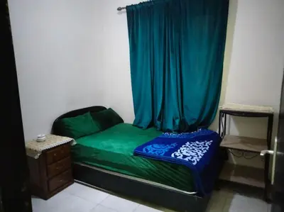a small bedroom with a green bed with a curtain at les porte de guiliz appartement in Marrakech