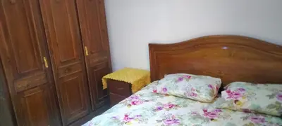 a bedroom with a bed with a wooden head board at les porte de guiliz appartement in Marrakech