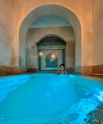 a person sitting in a hot tub in a building at Riad Dar Zaouia in Marrakech