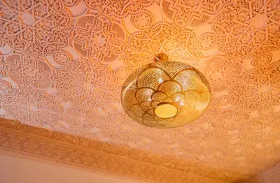 a gold chandelier hanging from a ceiling at Riad L'ECOLE in Marrakech