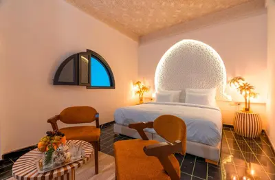 a hotel room with a bed and a table at Riad L'ECOLE in Marrakech