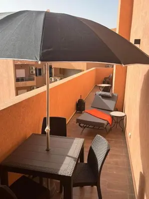 a black table with an umbrella on a balcony at Nid douillet à Gueliz in Marrakech