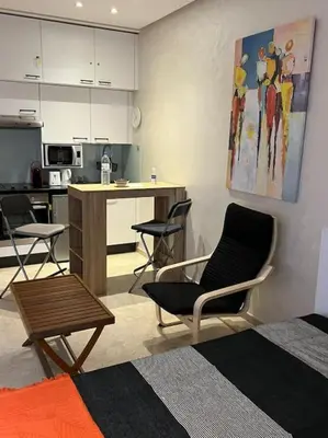 a living room with a kitchen with chairs and a table at Nid douillet à Gueliz in Marrakech