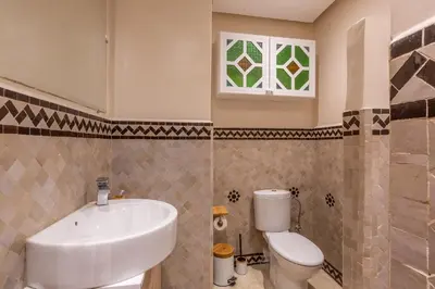 a bathroom with a sink and a toilet and a window at Le Palmier - Appartement Authentique à Gueliz in Marrakech