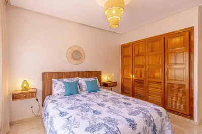 a bedroom with a large bed with blue pillows at Le Palmier - Appartement Authentique à Gueliz in Marrakech