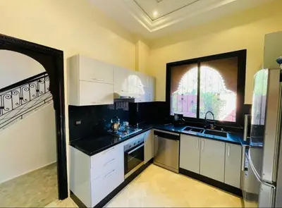a kitchen with white cabinets and a large window at The Villa avec piscine chauffée 4 chambres in Marrakech