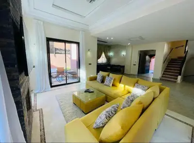 a living room with a yellow couch and a table at The Villa avec piscine chauffée 4 chambres in Marrakech