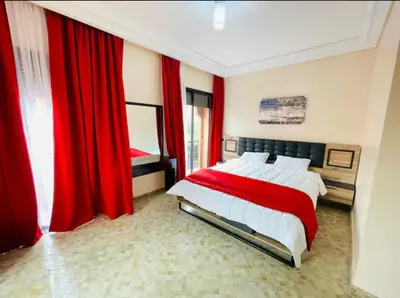 a bedroom with a large bed with red curtains at The Villa avec piscine chauffée 4 chambres in Marrakech