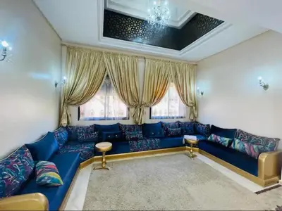 a blue couch in a living room with windows at The Villa avec piscine chauffée 4 chambres in Marrakech