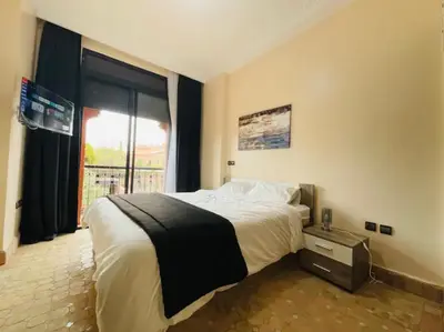 a bedroom with a large bed and a window at The Villa avec piscine chauffée 4 chambres in Marrakech