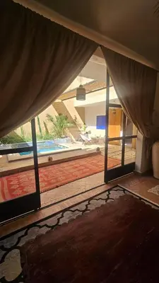 a living room with a view of a swimming pool at Riad Laila Marrakech in Marrakech