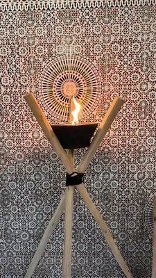 a candle on a wooden stand in front of a wall at Riad Hayat in Marrakech