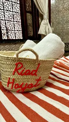 a basket with the words raid hollywood sitting on a bed at Riad Hayat in Marrakech