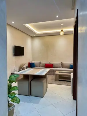 a living room with a couch and a table at Charmant Appartement au Cœur de la Ville in Marrakech