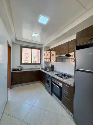 a large kitchen with a stove and a dishwasher at Charmant Appartement au Cœur de la Ville in Marrakech