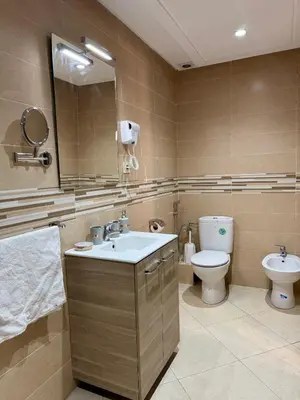 a bathroom with a sink and a toilet and a mirror at Charmant Appartement au Cœur de la Ville in Marrakech