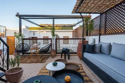 a living room with a blue couch on a patio at Riad Thé d'Orient - Piscine Privée - Petit Déjeuner in Marrakech