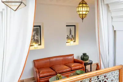 a living room with a brown leather couch at Riad Thé d'Orient - Piscine Privée - Petit Déjeuner in Marrakech
