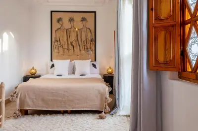 a bedroom with a bed and a painting on the wall at Riad Thé d'Orient - Piscine Privée - Petit Déjeuner in Marrakech