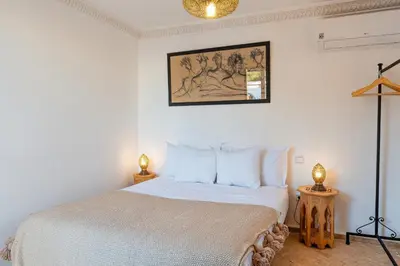 a bedroom with a bed and a picture on the wall at Riad Thé d'Orient - Piscine Privée - Petit Déjeuner in Marrakech