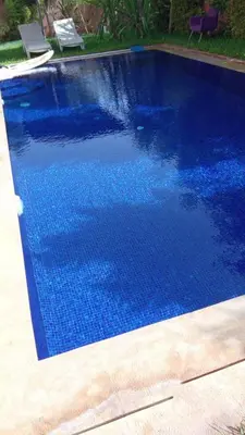 a swimming pool with blue water in a yard at Villa avec pool privé avenue Mohamed 6 zone touristique Agdal in Marrakech