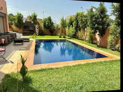 a swimming pool in the yard of a house at Villa avec pool privé avenue Mohamed 6 zone touristique Agdal in Marrakech