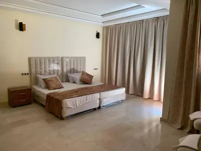 a bedroom with a bed and a large window at Villa avec pool privé avenue Mohamed 6 zone touristique Agdal in Marrakech