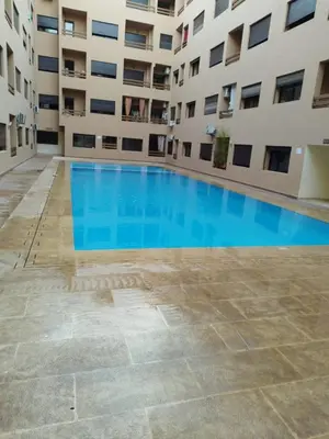 an empty swimming pool in front of a building at Luxury Apartment Marrakesh in Marrakech