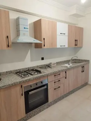 a kitchen with wooden cabinets and a stove top oven at Luxury Apartment Marrakesh in Marrakech