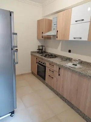 a kitchen with wooden cabinets and a stove top oven at Luxury Apartment Marrakesh in Marrakech