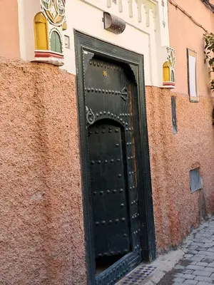 a black door on the side of a building at Riad El Badii chambre twin Bahia in Marrakech