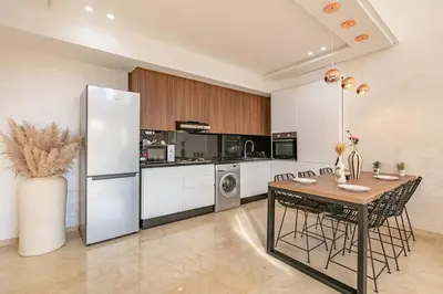 a kitchen with a table and a refrigerator at Duplex Design, Terrasse résidence Menara garden in Marrakech