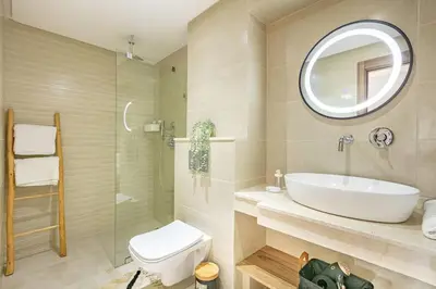 a bathroom with a sink and a toilet and a mirror at Duplex Design, Terrasse résidence Menara garden in Marrakech