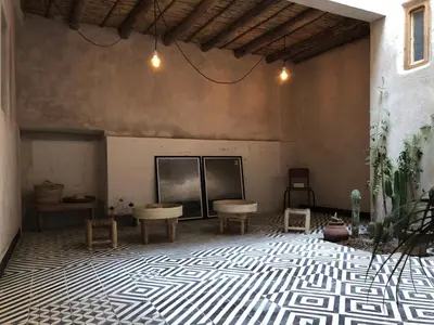 a room with a table and chairs on a tiled floor at Dar Oki in Marrakech