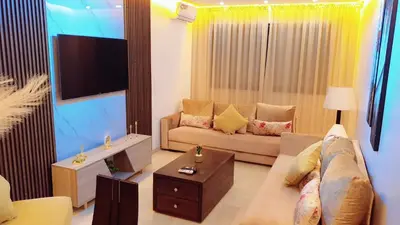 a living room with a couch and a tv at Appartement de Haut Standing. in Marrakech