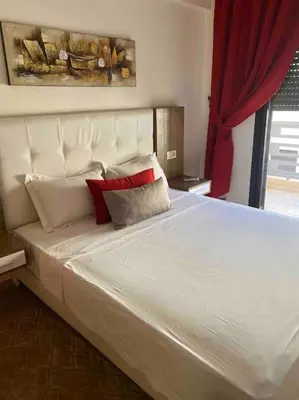a bedroom with a large white bed with red pillows at Appartement de Haut Standing. in Marrakech