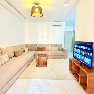 a living room with a couch and a flat screen tv at Studio N9 COSY Avec Balcon in Marrakech