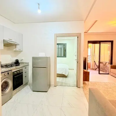 a kitchen with a refrigerator and a room with a bed at Studio N9 COSY Avec Balcon in Marrakech