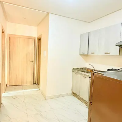 an empty kitchen with a sink and a door at Studio N9 COSY Avec Balcon in Marrakech