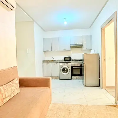 a kitchen with a couch and a refrigerator at Studio N9 COSY Avec Balcon in Marrakech