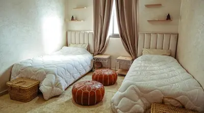 a bedroom with two beds and two ottomans at Apartment in Marrakech in Marrakech