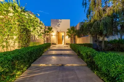 a walkway in front of a building with trees at Villa Tomazo Marrakech in Marrakech