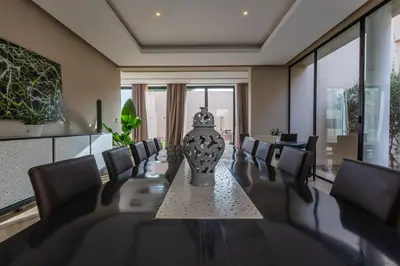 a dining room with a long table and chairs at Villa Tomazo Marrakech in Marrakech