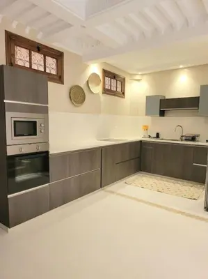 a large kitchen with a stove and a microwave at Riad Isahiac avec piscine en exclusivité in Marrakech