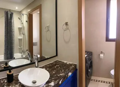 a bathroom with a sink and a mirror at Vizir Center Appartement avec solarium in Dar Caïd Layadi