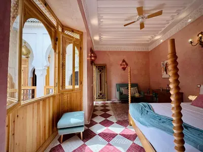 a bedroom with a bed and a ceiling fan at Riad LallaBaya in Marrakech